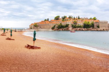 Karadağ 'daki Sveti Stefan adası Adriyatik denizi, çam ağacı ve sahil manzaralı tatil beldesi