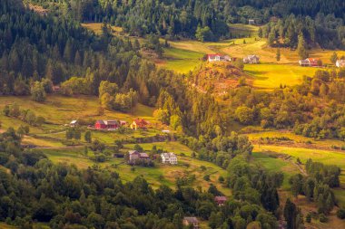 Gün batımı Norveçli Köyü manzara, yeşil orman Dağları ve renkli evleri, Norveç