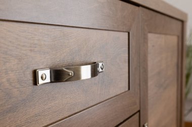 Kahverengi çekmecenin metal sapı, evin içi, yakın plan.