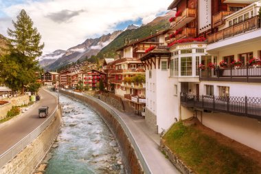 Zermatt, İsviçre - 7 Ekim 2019: Alp köyü panoraması, İsviçre Alpleri, geleneksel ahşap evler, kar dağları ve nehir