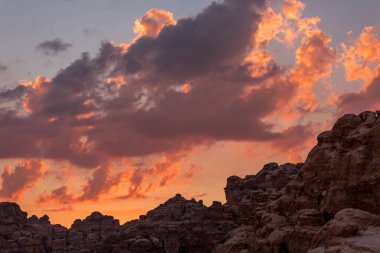Sunset colorful orange sky landscape with sandstone rocks in Little Petra archaeological site, Jordan clipart