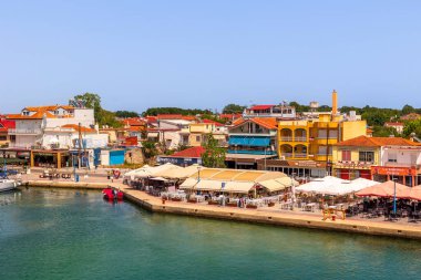 Keramoti, Yunanistan - 12 Haziran 2024: Tekne, gezinti manzaralı, tavernalı, cafeli ve restoranlı kasaba limanı