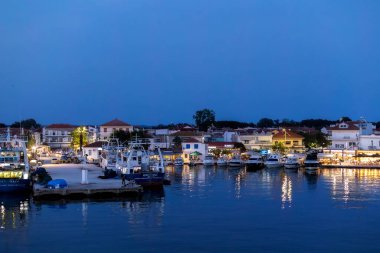 Keramoti, Yunanistan - 12 Haziran 2024: Limanı, feribot ve restoranlarıyla akşam mavisi manzarası