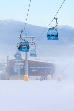 Bansko, Bulgaristan - 21 Ocak 2024: Sisli yamaçlı Bulgar kış kayak merkezi, kardan sonra kabinler ve teleferik istasyonu