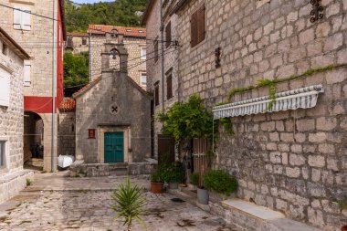 Perast, Karadağ - 21 Eylül 2023: Eski evleri ve kilisesi olan ünlü Kotor Körfezi 'ndeki tarihi kasaba manzarası