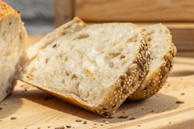 Ev yapımı taze ekmek ve mutfak masasında dilimler. Ekşi buğday ekmekli çavdar ekmeği. Tohumlar yakından görülüyor.