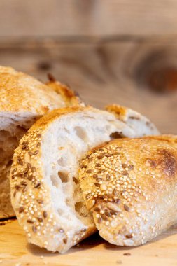 Ev yapımı taze ekmek ve mutfak masasında dilimler. Ekşi buğday ekmekli çavdar ekmeği. Tohumlar yakından görülüyor.