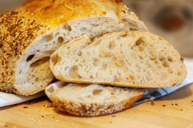Ev yapımı taze ekmek ve mutfak masasında dilimler. Ekşi buğday ekmekli çavdar ekmeği. Tohumlar yakından görülüyor.