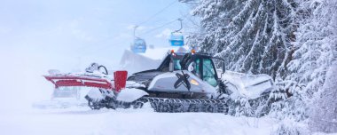 Bansko, Bulgaria - January 21, 2024: Snow groomer snowcat ratrack machine preparing ski slope for alpine skiing, winter resort clipart