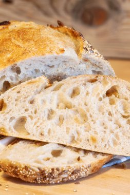 Ev yapımı taze ekmek ve mutfak masasında dilimler. Ekşi buğday ekmekli çavdar ekmeği. Tohumlar yakından görülüyor.