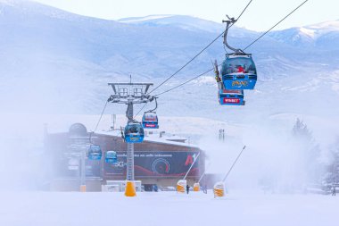 Bansko, Bulgaristan - 21 Ocak 2024: Sisli yamaçlı Bulgar kış kayak merkezi, kardan sonra kabinler ve teleferik istasyonu