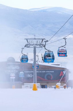 Bansko, Bulgaristan - 21 Ocak 2024: Sisli yamaçlı Bulgar kış kayak merkezi, kardan sonra kabinler ve teleferik istasyonu