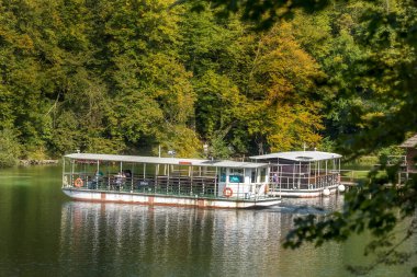Plitvice Lakes, Hırvatistan - 22 Eylül 2024: Gezi teknesi üzerindeki turistler, Plitvice Gölleri Ulusal Parkı 'nın sonbahar manzarası