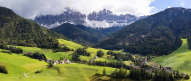 Dolomitler, İtalya. St. Magdalena ya da Santa Maddalena kilisesi, Geisler Odle dağları ve yeşil dağların geniş panoramik manzarası.