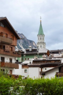 İtalya, Cortina d 'Ampezzo' nun güzel sonbahar manzarası. Alp evleri ve kilise çan kulesi var.