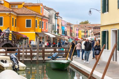Burano Adası, İtalya - 1 Ekim 2024 Venedik yakınlarındaki ünlü adada renkli evler mimari, kanal ve cadde. Seyahat ve tatil kavramı