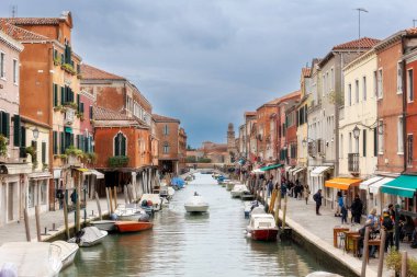 Murano Adası, İtalya - 1 Ekim 2024 Venedik yakınlarındaki ünlü adada renkli evler mimari, kanal ve cadde. Seyahat ve tatil kavramı