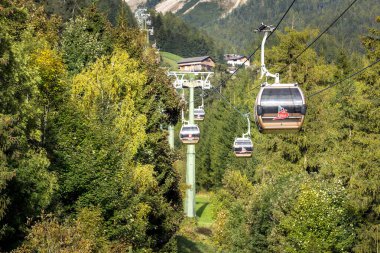 Ortisei, Italy - September 29, 2024: Cable car cabins to Furnes, part of Seceda trip in Val Gardena, Dolomites Alps in autumn clipart