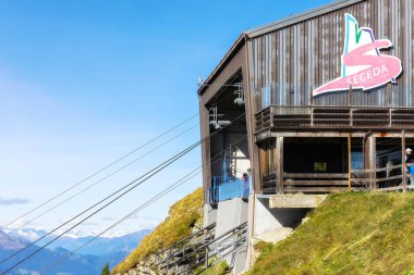 Ortisei, Italy - September 29, 2024: Cable car station Seceda in Val Gardena, Dolomites Alps and snow peaks in autumn clipart