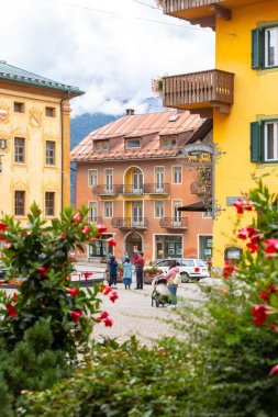 Cortina d 'Ampezzo, İtalya - 24 Eylül 2024: Alp evleri ve dağlarla dolu güzel bir sonbahar sokak manzarası