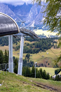 chair lift waiting for the season at the station, Dolomites Alpe di Siusi, Italy in summer clipart