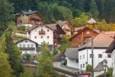 Ortisei, Italy- 26 Eylül 2024: Dolomites 'teki Alp köyü yaz manzaralı renkli evler