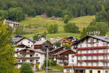 Cortina d 'Ampezzo, İtalya - 24 Eylül 2024: Alp evleri ve dağlarla dolu güzel bir sonbahar sokak manzarası