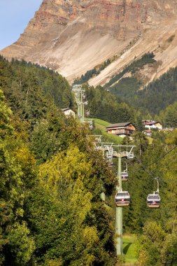 Ortisei, İtalya - 29 Eylül 2024: Sonbaharda Dolomites Alpleri 'nin Val Gardena kentinde yapılacak Seceda gezisinin bir parçası olan Furnes' e kablo araba kulübeleri