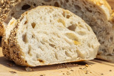 Ahşap kesim tahtasındaki bir somundan dilimlenmiş bir parça ekşi ekmek. Ev yapımı kavramı.