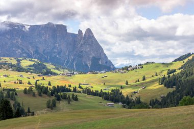 Alpe di Siusi, Güney Tyrol, İtalya 'da geleneksel ahşap dağ kulübeleriyle Dolomitlerin manzara manzarası
