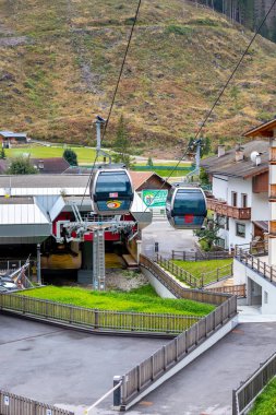 Canazei, Italy - September 26, 2024: Cable car station and cabins to Belvedere, summer view of village in Fassa valley in Trentino Alto Adige clipart