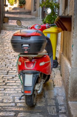 Kırmızı Scooter Avrupa 'nın eski caddesinde park halinde.