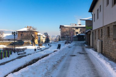 Bansko, Bulgaristan - 18 Ocak 2025: Gotse Delchev sokak manzaralı eski, geleneksel evler, kışın akan su