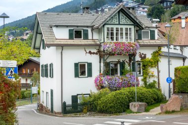 Ortisei, Italy- 26 Eylül 2024: Dolomites 'teki Alp köyü yaz manzaralı renkli evler