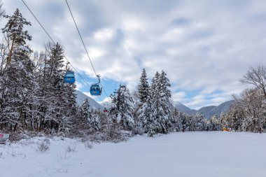 Bansko, Bulgaristan - 17 Ocak 2025: Kayak teleferiği, gondol kulübeleri ve kar dağları ve kar yağışı sonrasında kayak yolu yamacıyla kış tatil beldesi