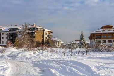 Bansko, Bulgaria winter street view, houses and Pirin snow mountain in bulgarian ski resort clipart