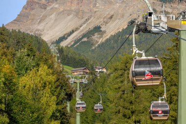 Ortisei, İtalya - 29 Eylül 2024: Sonbaharda Dolomites Alpleri 'nin Val Gardena kentinde yapılacak Seceda gezisinin bir parçası olan Furnes' e kablo araba kulübeleri
