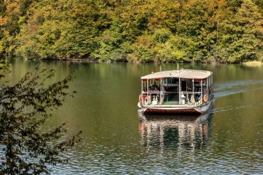 Plitvice Lakes, Hırvatistan - 22 Eylül 2024: Gezi teknesi üzerindeki turistler, Plitvice Gölleri Ulusal Parkı 'nın sonbahar manzarası