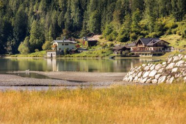 Alleghe, Veneto, İtalya - 24 Eylül 2024: Alleghe Gölü kıyısındaki evler, Dolomitler Alp Dağları