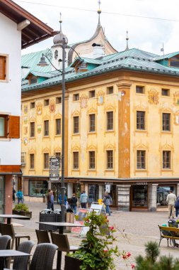Cortina d 'Ampezzo, İtalya - 24 Eylül 2024: Alp evleri ve dağlarla dolu güzel bir sonbahar sokak manzarası