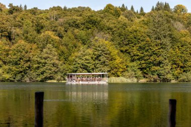 Plitvice Lakes, Hırvatistan - 22 Eylül 2024: Gezi teknesi üzerindeki turistler, Plitvice Gölleri Ulusal Parkı 'nın sonbahar manzarası