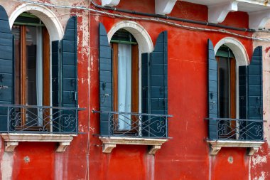 Burano adası, çiçekli İtalya pencereleri, renkli kırmızı ev mimarisi, Venedik yakınlarındaki ünlü bir adada sokak. Seyahat ve tatil kavramı