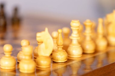 Satranç tahtasındaki tahta satranç taşları. Entelektüel oyun. Beyaz atlı prens odaklan.
