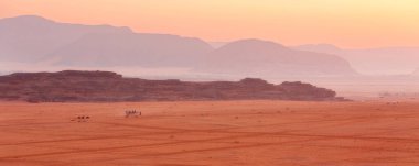 Ürdün, Wadi Rum, kırmızı kum tepeciği, deve kervanı ve güzel kayalar manzarası
