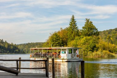 Plitvice Lakes, Hırvatistan - 22 Eylül 2024: Gezi teknesi üzerindeki turistler, Plitvice Gölleri Ulusal Parkı 'nın sonbahar manzarası