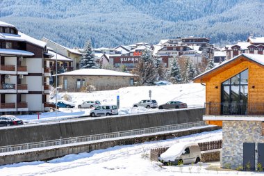 Bansko, Bulgaristan - 7 Nisan 2025: Bulgar kayak beldesinde kışın yüksek açılı cadde manzarası, evler ve Pirin karlı dağları