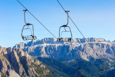 Dolomitlerin, Val Gardena dağlarının, İtalya 'nın üzerinde boş kayak koltukları dinleniyor.