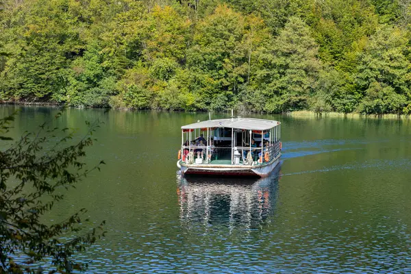 Plitvice Lakes, Hırvatistan - 22 Eylül 2024: Gezi teknesi üzerindeki turistler, Plitvice Gölleri Ulusal Parkı 'nın sonbahar manzarası