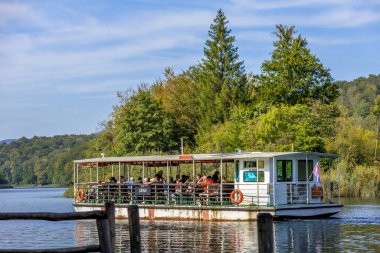 Plitvice Lakes, Hırvatistan - 22 Eylül 2024: Gezi teknesi üzerindeki turistler, Plitvice Gölleri Ulusal Parkı 'nın sonbahar manzarası
