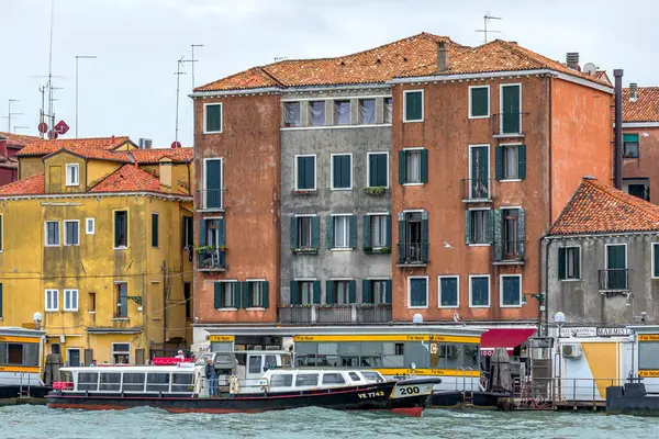 Venedik, İtalya - 1 Ekim 2024: Su taksisi veya otobüs, vaporetto ve arka planda güzel Venedik evleri.